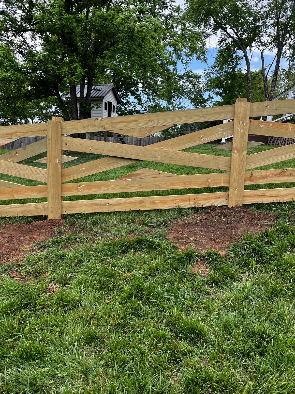 Wood cross-buck rail fence with X-brace panels in a farm yard