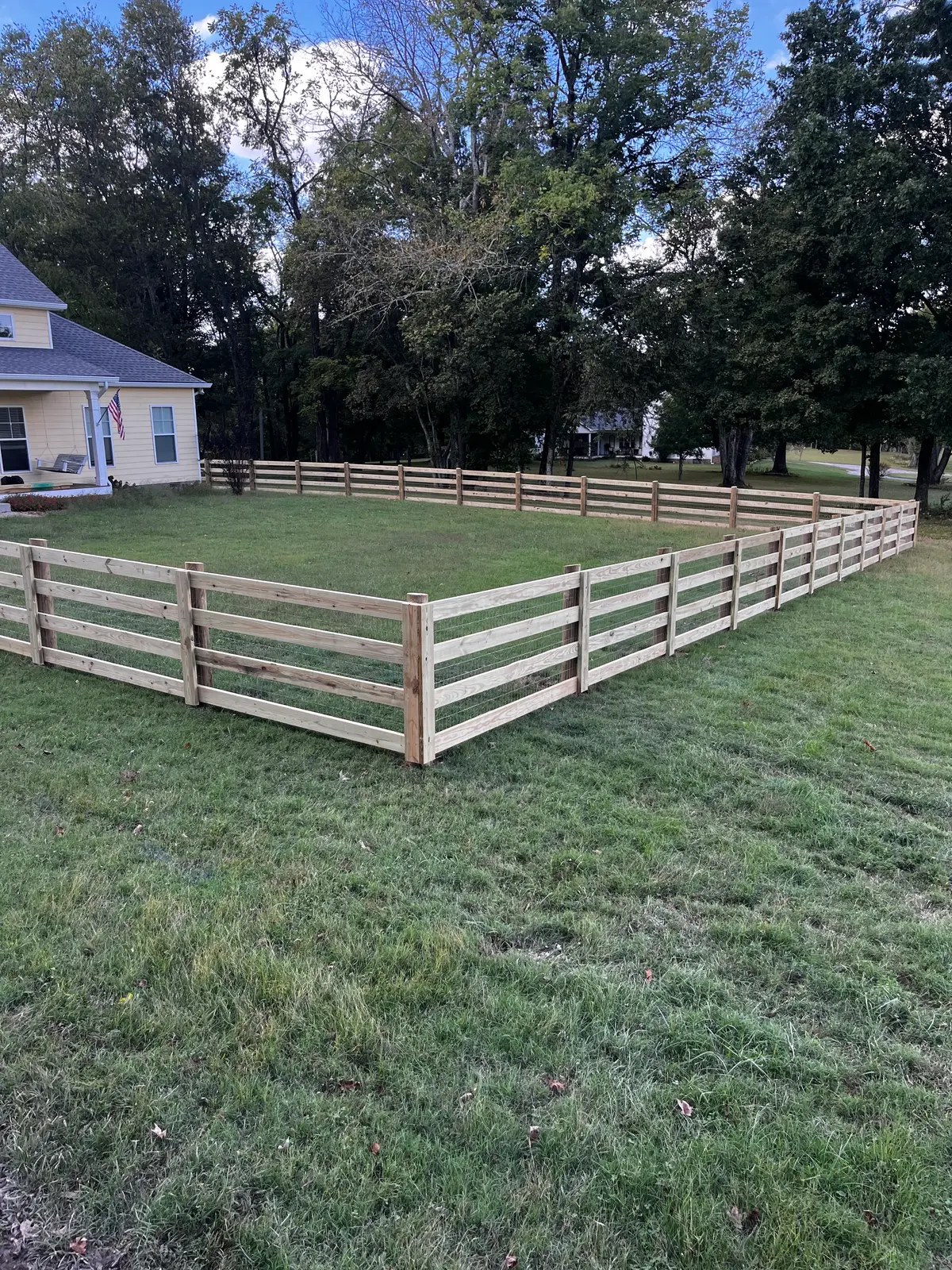 White-painted board fence enclosing a horse paddock