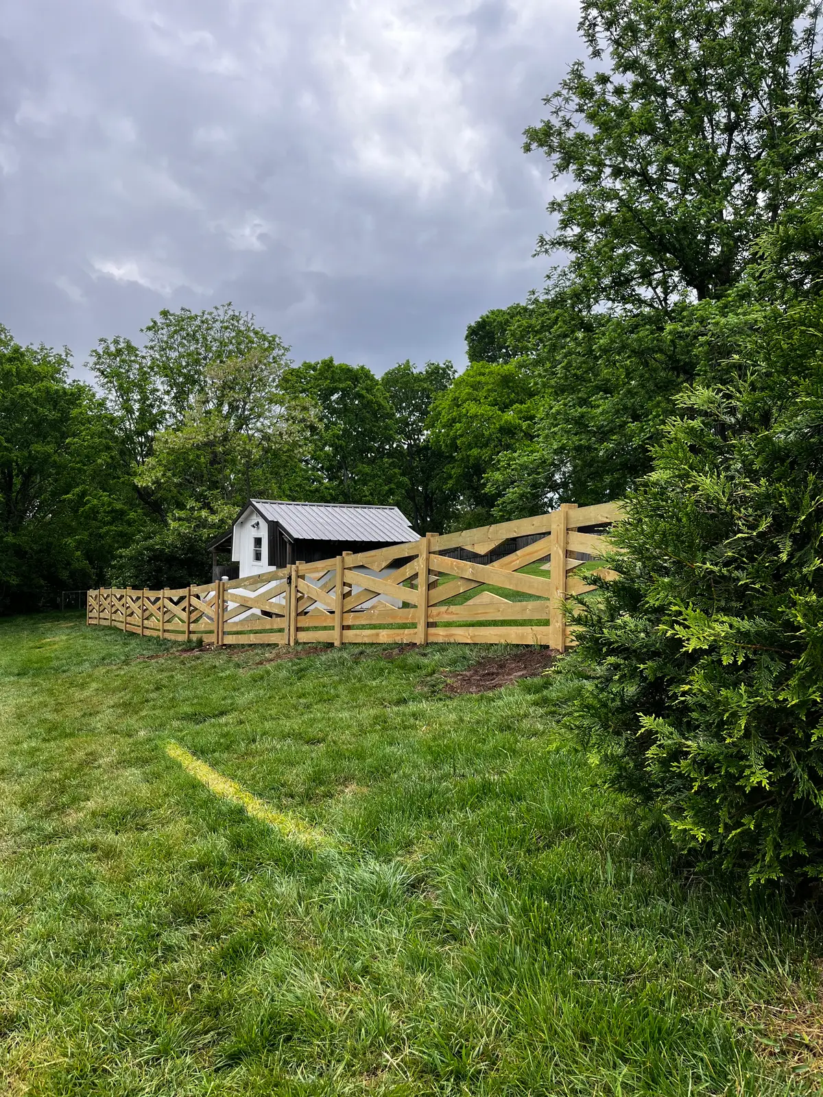 Wood cross-buck farm gate opening to a pasture