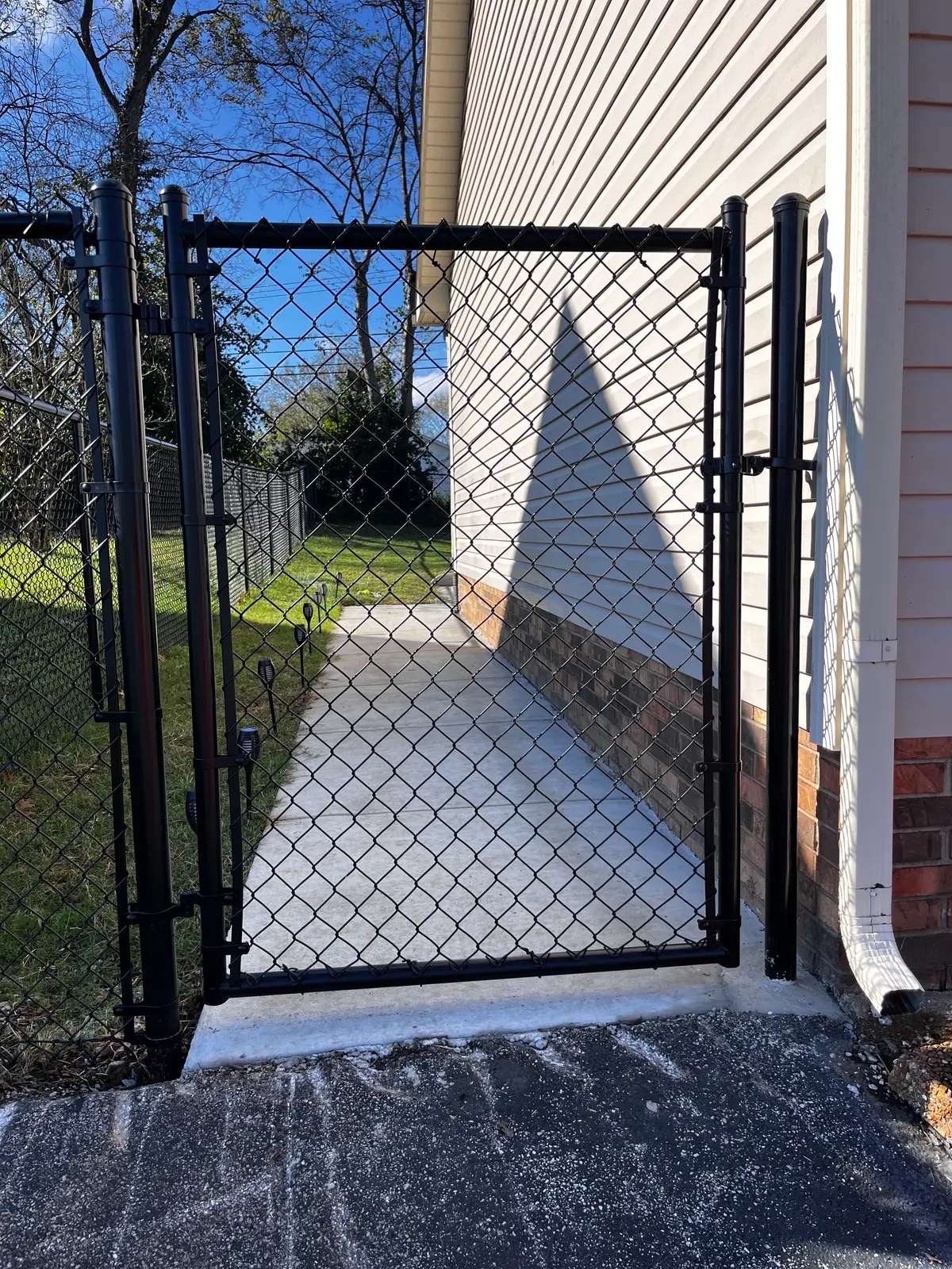 Ornamental iron driveway gate on brick columns at a Middle Tennessee country home