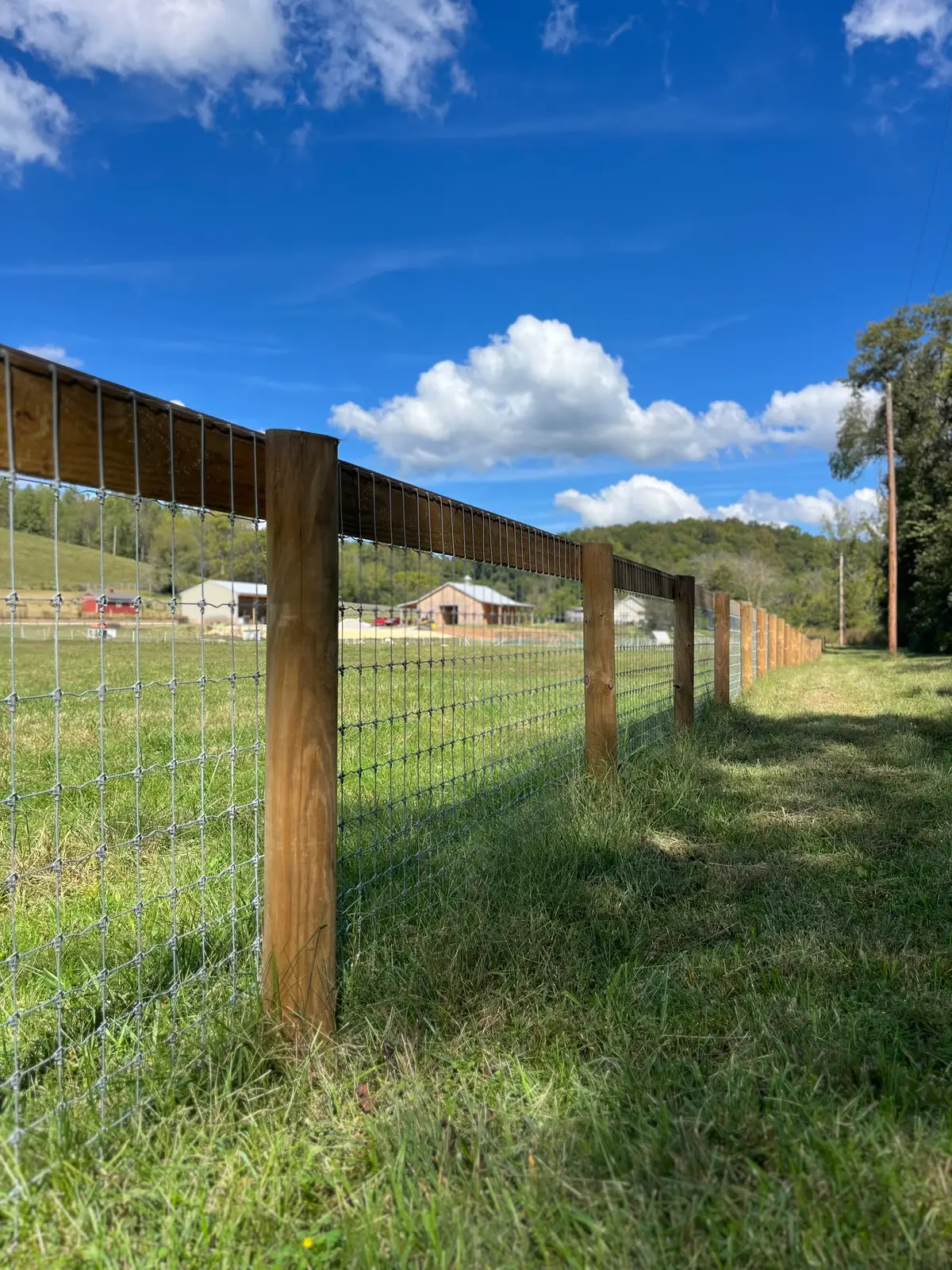 Wood-post and wire ranch fence running toward the horizon